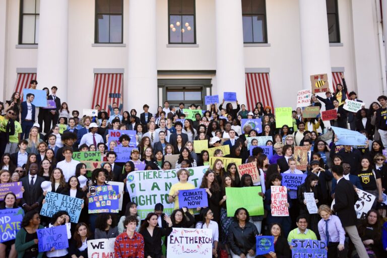 A photo of hundreds of young activists in front of the Florida state capitol - many are holding signs calling for "climate action now"